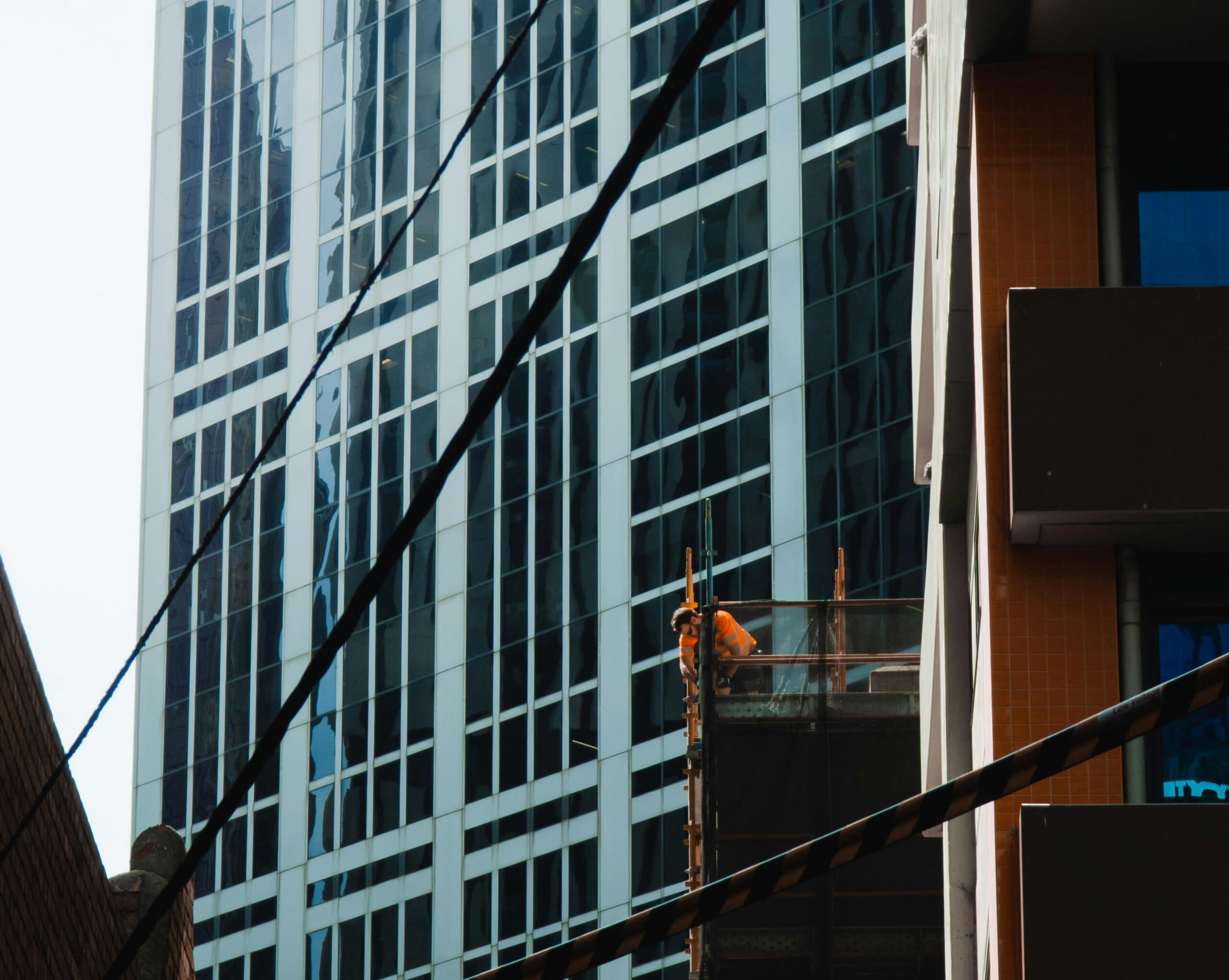 Tradie working. Outside of a building with a man in a high-vis vest working with tools.